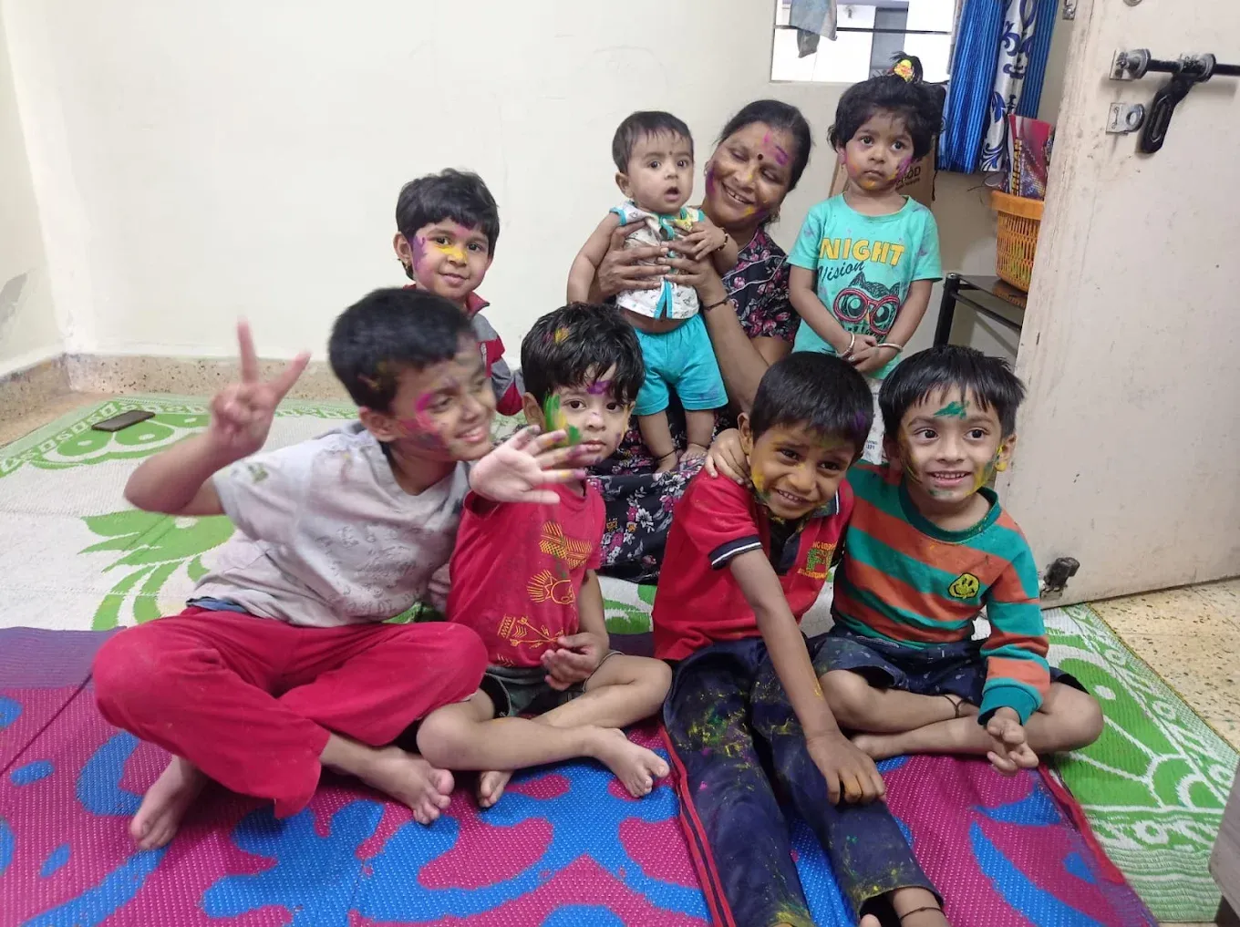 Kaku and children with colours on their faces celebrating Holi at Maza Ghar