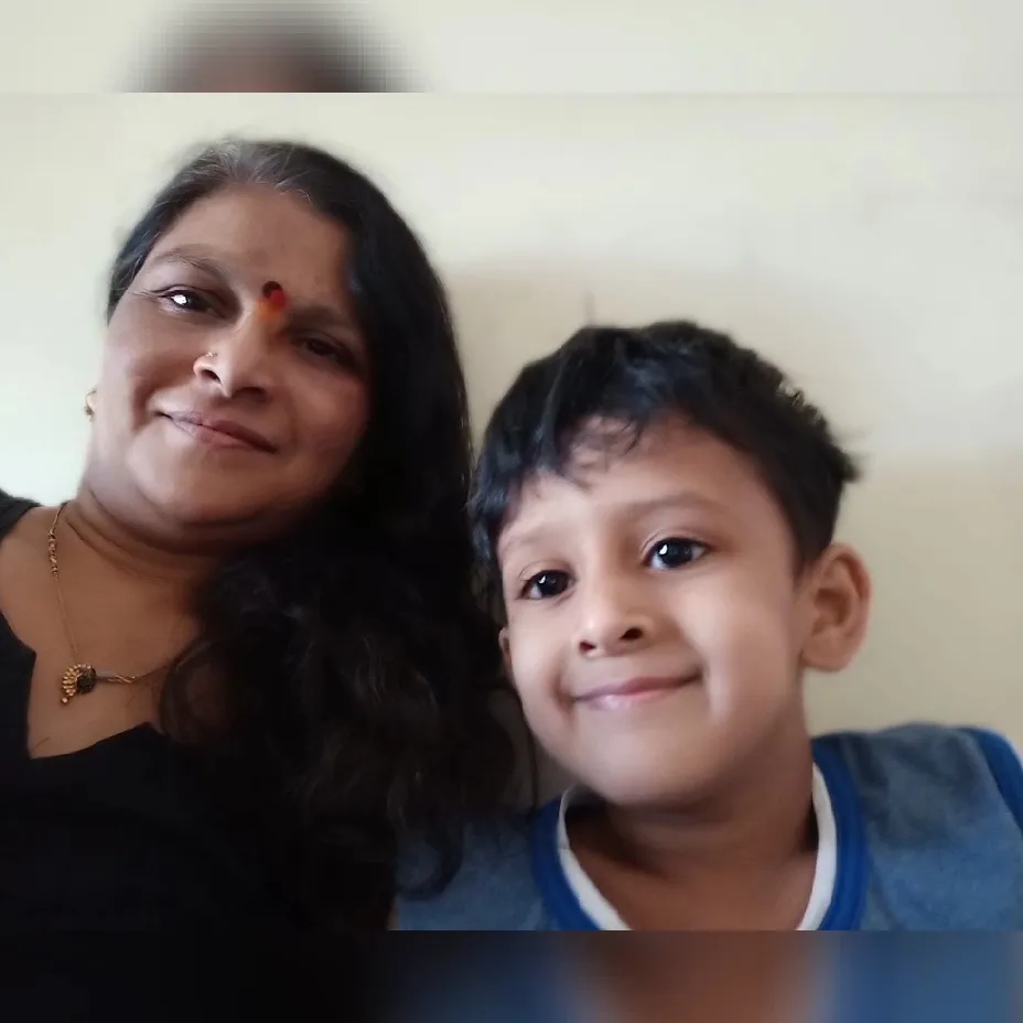 Kaku, the caretaker at Maza Ghar Day Care, smiling with one of the children